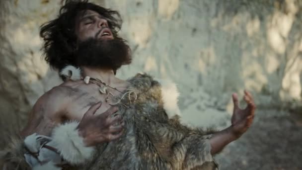 Portrait of Primeval Caveman Wearing Animal Skin Does Threatening Chest Beating and Screaming, Defending His Cave and Territory in the Prehistoric Times. Prehistoric Neanderthal or Homo Sapiens Leader — Stock Video