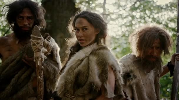 동물 스킨을 착용한 여성 지도자와 두 명의 원시 원시인이 선사 시대에서 동굴과 영토를 방어하면서 돌로 된 창, 비명을 지르며 적을 공격합니다. 네안데르탈인 / 호모 사피엔스 부족 — 비디오