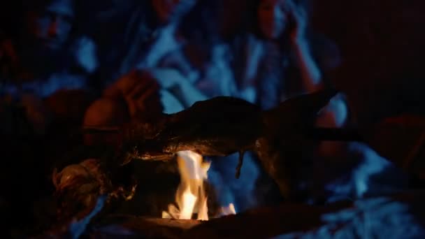 Neanderthaler of Homo Sapiens Familie Koken Dierlijk Vlees boven Bonfire en dan opeten. Stamboom van prehistorische jager-verzamelaars dragen dierenhuiden grillen en vlees eten in de grot 's nachts — Stockvideo