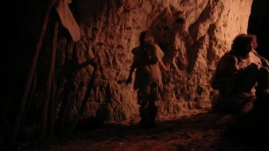 İlkel Tarih Öncesi Neandertal Çocuk Hayvan Derisi Giyen Gece Duvarlarda Hayvanlar ve Özetler Çizer. Petroglifler, Kaya Resimleri ile İlk Mağara Sanatı Oluşturma. Çekimden Sonra Geri Görünüm
