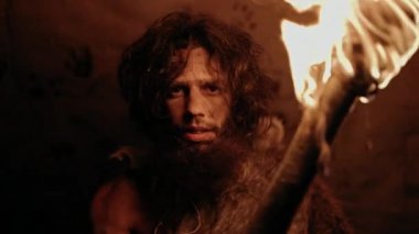 İlkel Mağara Adamı 'nın portresi Hayvan Derisi Giyen Gece Mağarasında Duran, Ateşli Meşale Tutan. İlkel Neandertal Avcısı / Homo Sapiens Gece Kuyusunda Tek Başına