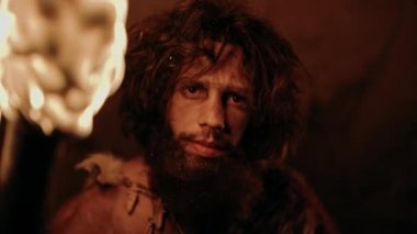 İlkel Mağara Adamı 'nın portresi Hayvan Derisi Giyen Gece Mağarasında Duran, Ateşli Meşale Tutan. İlkel Neandertal Avcısı / Homo Sapiens Gece Kuyusunda Tek Başına
