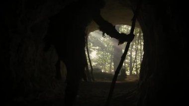 Hayvan derisi ve kürkü olan ilkel mağara adamı mağarasından çıkıp tarih öncesi ormanı avlamaya hazır hale geldi. Neanderthal Ormana Avlanmaya Gidiyor