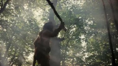 Hayvan Derisi Giyen Primeval Caveman Tutar Taş Uçlu Mızrak Prehistorik Orman Etrafında Görünüyor, Hayvan Av Hunt hazır. Neandertal Ormana Avlanmaya Gidiyor. Düşük Açılı Yavaş Hareket Ark Çekimi