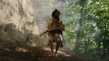 Hayvan Derisi Giyen Primeval Caveman Taş Uçlu Çekiç Tutar Mağara dan çıkar ve Etrafa bakar, Hayvan Av Hunt Hazır Prehistorik Orman Keşfetmek. Neandertal Ormana Avcılık Going