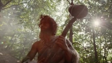Hayvan Derisi Giyen İlkel Mağara Adamı 'nın Silueti Tarih Öncesi Orman' da Hayvan Avlamaya Hazır Taş Tutucu Çekiç Bakıyor. Neanderthal Ormana Avlanmaya Gidiyor. Dramatik Düşük Açılı Çekim