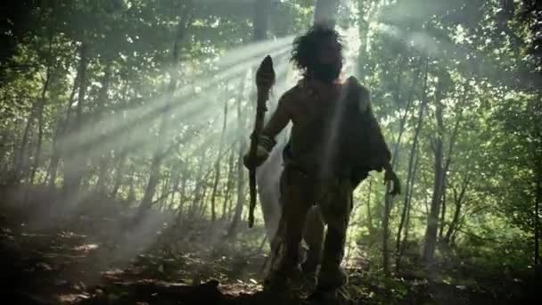 Primeval Caveman Wearing Animal Skin Holds Stone Tipped Spear Looks Around, Explores Prehistoric Forest in a Hunt for Animal Prey. Neanderthal Going Hunting in the Jungle — Stock Video