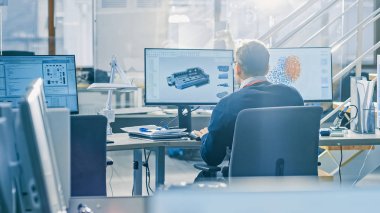 Bright Office'te Masaüstü Bilgisayarda Çalışan Endüstri Mühendisinin Arka Görünümü. Ekranlar Show Ide / Cad Yazılım, Makine Öğrenimi, Sinirsel Ağ ve Bulut Bilişim Uygulaması
