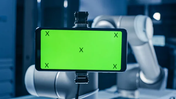 Robot ramię trzyma zielony makiety ekranu smartphone w trybie poziomym. Przemysłowe roboty Manipulator End Effector trzyma telefon komórkowy z Chroma Display Key. — Zdjęcie stockowe