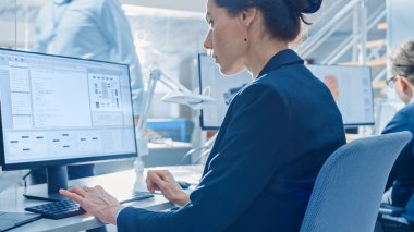 Bright Office'te Masaüstü Bilgisayarlarda Çalışan Teknoloji Mühendisleri Ekibinin Geri Görünümü. Ekranlar Show Ide / Cad Yazılım, Makine Öğrenimi, Sinirsel Ağ ve Bulut Bilişim Uygulaması
