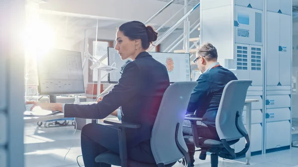 Back View of Team of Technology Engineers Working on Desktop Computers in Bright Office. Screens Show IDE / CAD Software, Implementation of Machine Learning, Neural Networking and Cloud Computing