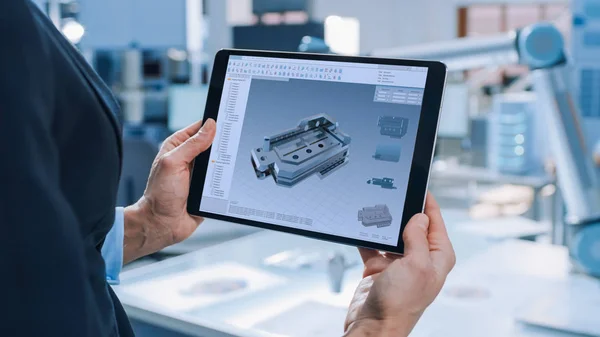 Elegante ingeniera de robótica industrial femenina utiliza Tablet Computer con software CAD y para manipular y programar brazo de robot para levantar, mover objetos, tecnología, centro de investigación para el aprendizaje automático — Foto de Stock