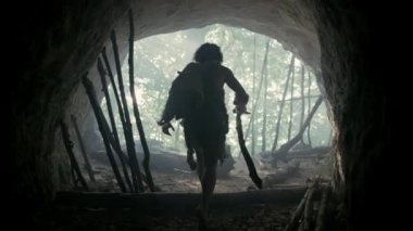 Hayvan Derisi Giyen İlkel Caveman, Kürk Tutar Taş Uçlu Mızrak Av için Hazır Tarih Öncesi Orman içine Mağarasından çıkar. Neandertal Ormana Avlanmaya Gidiyor. Takip ve Portre Çekimi