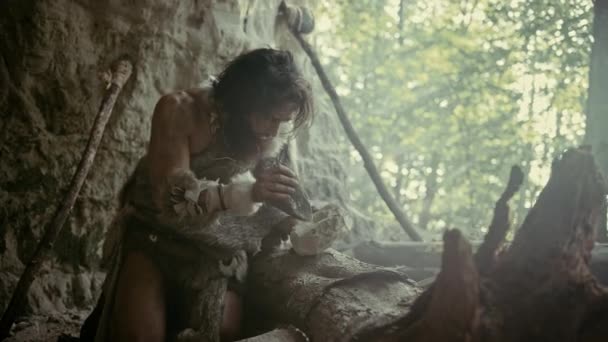Primeval Caveman draagt Animal Skin Hits Rock met scherpe steen en maakt het eerste primitieve gereedschap voor de jacht op dierlijke prooien of voor het hanteren van huiden. Neanderthaler met Handax. De dageraad van de menselijke beschaving — Stockvideo