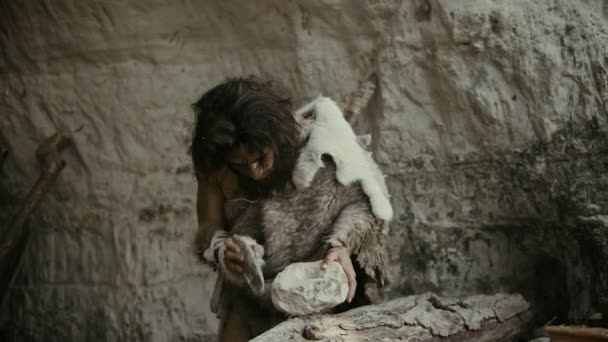 Primeval Caveman indossa pelle animale colpisce roccia con pietra tagliente e rende strumento primitivo per la caccia di prede animali. Neanderthal Usando Flint Rock per creare la prima ruota. Colpo al rallentatore — Video Stock