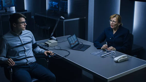 Female Special Agent Conducts Lie Detector / Polygraph Test on a Young Suspect. Expert Examiner Questions Accused in Interrogation Room. Laptop Records Reactions. — Stock Photo, Image