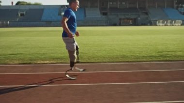 Protez Koşu Bıçakları ile Atletik Engelli Fit Man Güneşli Bir Öğleden Sonra Bir Açık Stadyumda Eğitim olduğunu. Ampute Koşucu Bir Stadyum Pisti'nde Koşu. Motivasyonel Spor Görüntüleri. Takip Çekimi.