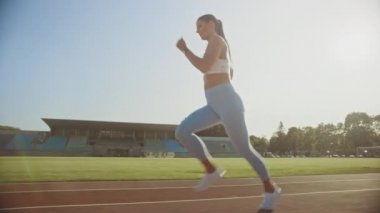 Açık Mavi Atletik Top ve Tozluk Bir Stadyumda Jogging Güzel Fitness Girl. O Sıcak bir yaz öğleden sonra çalışıyor. Atlet Bir Yolda Rutin Spor Uygulama Yapıyor. Yavaş Çekim.