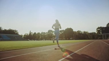 Açık Mavi Atletik Top ve Tozluk Bir Stadyumda Jogging Güzel Fitness Woman. O Sıcak bir yaz öğleden sonra çalışıyor. Atlet Bir Yolda Rutin Spor Uygulama Yapıyor. Yavaş Çekim.