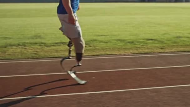 Athletic Disabled Fit Man with Prosthetic Running Blades está entrenando en el estadio al aire libre en una tarde soleada. Amputee Runner Jogging on Stadium Track. Filmación deportiva motivacional. Primer plano tiro de la pierna . — Vídeos de Stock