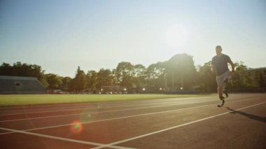 Protez Koşu Bıçakları ile Atletik Engelli Fit Man Güneşli Bir Öğleden Sonra Bir Açık Stadyumda Eğitim olduğunu. Ampute Koşucu Bir Stadyum Pisti'nde Koşu. Motivasyonel Spor Görüntüleri. Takip Çekimi.