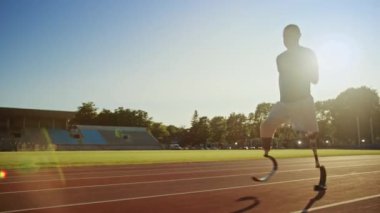Protez Koşu Bıçakları ile Atletik Engelli Fit Man Güneşli Bir Öğleden Sonra Bir Açık Stadyumda Eğitim olduğunu. Ampute Koşucu Bir Stadyum Pisti'nde Koşu. Motivasyonel Spor Görüntüleri. Takip Çekimi.