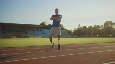 Protez Koşu Bıçakları ile Atletik Engelli Fit Man Güneşli Bir Öğleden Sonra Bir Açık Stadyumda Crossed Arms ile Poz olduğunu. Ampute Eki koşucu pistte duruyor. Motivasyonel Spor Görüntüleri.