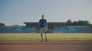 Protez Koşu Bıçakları ile Atletik Engelli Fit Man Güneşli Bir Öğleden Sonra Bir Açık Stadyumda Bir Eğitim Sırasında Poz olduğunu. Ampute Eki koşucu pistte duruyor. Motivasyonel Spor Görüntüleri.