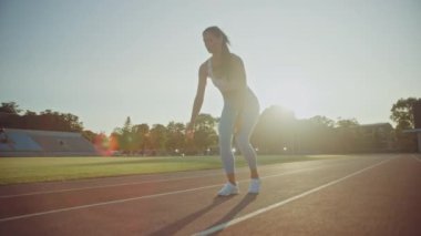 Açık Mavi Atletizm Üstündeki Güzel Fitness Kadını ve Leggings Açık Hava Stadyumu 'nda Koşuya Başlıyor. Sıcak bir yaz gününde koşuyor. Spor Antrenmanı Yapan Sporcu.
