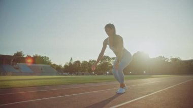 Açık Mavi Atletizm Üstündeki Güzel Fitness Kadını ve Leggings Açık Hava Stadyumu 'nda Koşuya Başlıyor. Sıcak bir yaz gününde koşuyor. Spor Antrenmanı Yapan Sporcu.