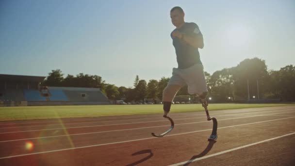 Atletický invalidní fit muž s protézového běžícím čepelí je trénink na venkovním stadionu během slunečného odpoledne. Ampionní běžec joggingu na dráze. Motivační sportovní záběr. Snímek sledování. — Stock video