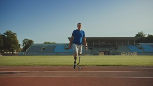 Athletic mozgáskorlátozottak Fit Man a fogpótlás Running Blades a pózol alatt képzés egy szabadtéri stadion egy napsütéses délután. Amputee Runner Standing egy pályán. Motivációs sport Footage. — Stock videók