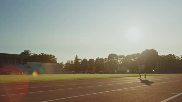 运动残疾人健身男子与假肢运行刀片是在阳光明媚的下午在户外体育场训练。截肢者跑步者在体育场跑道上慢跑。励志体育视频。静止拍摄. — 图库视频影像