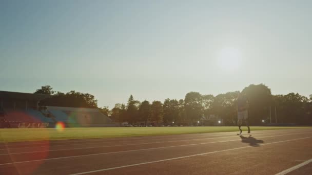 Athletic mozgáskorlátozottak Fit Man a fogpótlások Running Blades a képzés a szabadban stadion egy napsütéses délután. Amputee Runner jogging a stadion pályán. Motivációs sport Footage. Még lövés. — Stock videók