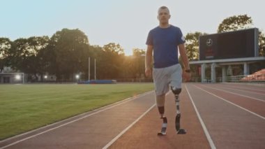 Protez Koşu Bıçakları ile Atletik Engelli Fit Man Güneşli Bir Öğleden Sonra Bir Açık Stadyumda Bir Eğitim Sırasında Yürüyor. Ampute Eki Koşucu koşuya hazırlanıyor. Motivasyonel Spor Görüntüleri.