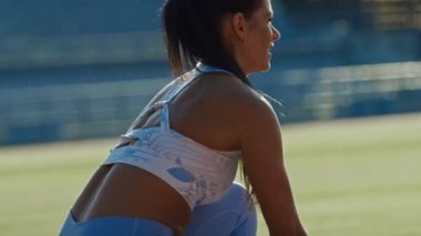Açık Mavi Atletik Top ve Tozluk Beautiful Fitness Woman Bir Açık Stadyumda Bir Sprint Run başlıyor. O Sıcak bir yaz gününde çalışıyor. Sporcu spor antrenmanı yapıyor. Çekimi Kapat.