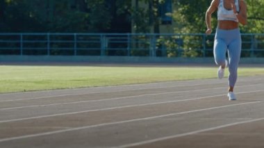 Açık Mavi Atletik Top ve Tozluk Bir Stadyumda Jogging Güzel Fitness Woman. O Sıcak bir yaz öğleden sonra çalışıyor. Atlet Bir Yolda Rutin Spor Uygulama Yapıyor. Yavaş Çekim.