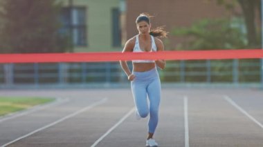 Beautiful Fit Kadın Runner Profesyonel Spor Arena'da Bitiş Çizgisini Geçiyor. Atletizm Kadını Stadyumda Yarışıyor. Zafer Başarısını Kutluyoruz. Motive Esmer Ellerini Yukarı Yükselterek.