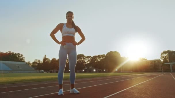 Krásná Fitness žena v světle modré sportovní top a legíny je chytit dech a pózování na stadionu. Trénovala na teplém letním odpoledni a dělala rutinní cvičení. — Stock video