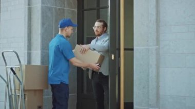 Teslimatçı, Elektronik İmza Pod Cihazı imzalayan bir müşteriden posta paketi alıyor. Teslimatı kamyonetine yükler. İş Dünyasında Kurye Bir Adamdan Karton Kutu Paketi Aldı