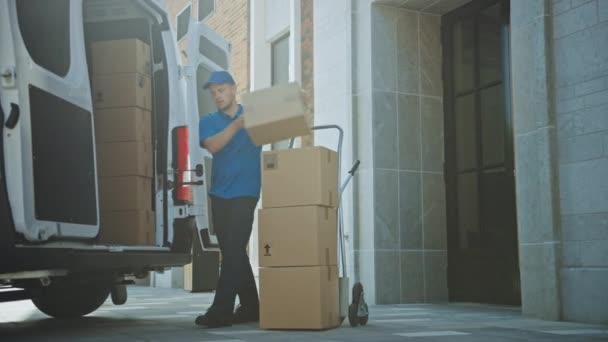 Delivery Man utiliza carro de mano lleno de cajas de cartón y paquetes, carga paquetes en camión / camioneta. Mensajero / cargador profesional que lo ayuda a moverse, entregando sus artículos comprados eficientemente — Vídeo de stock