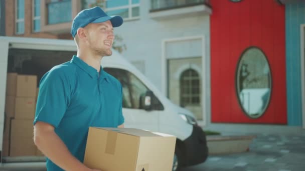 便利なクーリエは、現代的なスタイリッシュなビジネス地区を通って配達ヴァンウォークから段ボール箱パッケージを取ります。郵便小包を顧客に配達するための方法で宅配便 — ストック動画
