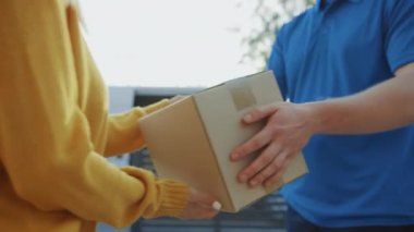 Güzel Genç Kadın Onu Karton Kutu Paketi verir Teslimat Adam Meets, O Elektronik İmza Pod Cihazı İmzalar. Banliyö Mahallesi'nde Kurye Teslim Parsel. Kutuya Odaklan