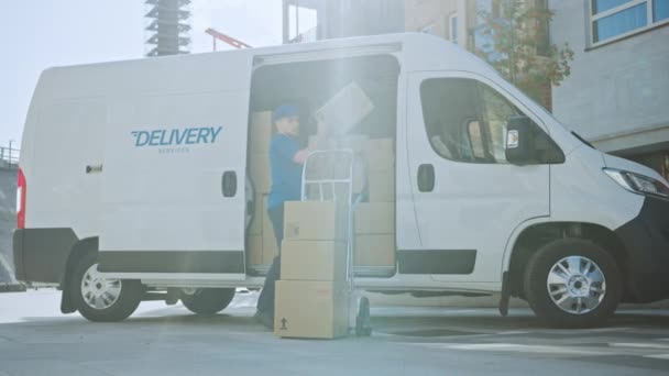 Courier ouvre la porte latérale du fourgon de livraison et sort le paquet de boîte en carton, ferme la porte et continue à livrer le colis postal . — Video