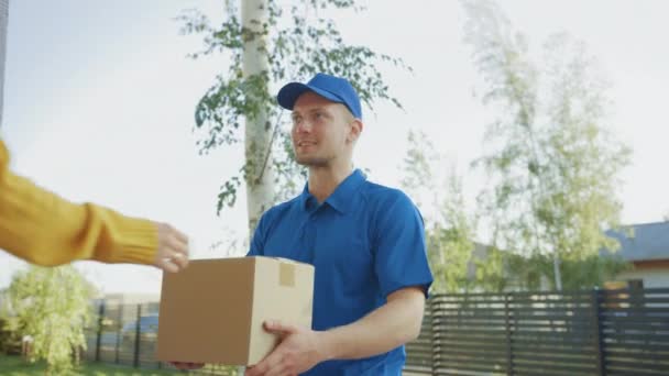 Mooie jonge vrouw voldoet aan de levering Man die haar kartonnen doos pakket geeft, ze tekent elektronische handtekening POD apparaat. Koerier Pakket bezorgen in de voorstedelijke buurt — Stockvideo