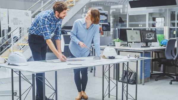 Na Agência de Engenharia: Engenheira Feminina e Técnica Masculina Trabalhando em Design para Protótipo de Motor Industrial. Especialistas falam durante reuniões, trabalho com desenhos. — Fotografia de Stock