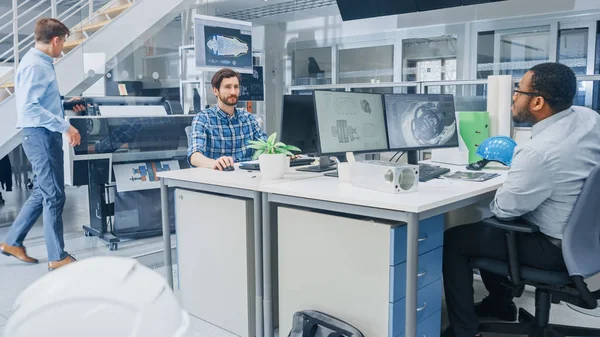 In the Busy Engineering Facility: Diverse Group of Engineers, Technicians, Specialists Working on Design for Industrial Engine Prototype. Profissionais falam, trabalham com desenhos, usam computadores — Fotografia de Stock