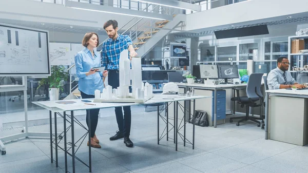 In Architectural Bureau: Architect and Engineer Talking, Working on a Building Complex Prototype Project, Using City Model and Computers Running 3D CAD Software. Quartiere residenziale o commerciale — Foto Stock