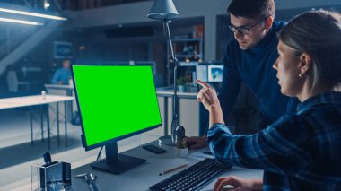 Masaüstü Bilgisayarı 'nda çalışan mühendis, 3D Motor Prototipi ile CAD yazılımını gösteriyor. Mühendislik Tesisinde Gece yarısı, Duvarlara Çizimler ve Planlar. Omzunun üstünden.