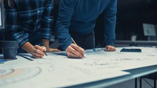 Primo piano girato con focus sulle mani di ingegneri maschi e femmine Lavorare su un progetto utilizzando matite sul tavolo della conferenza. Nel Dark Industrial Design Engineering Facility. — Foto Stock